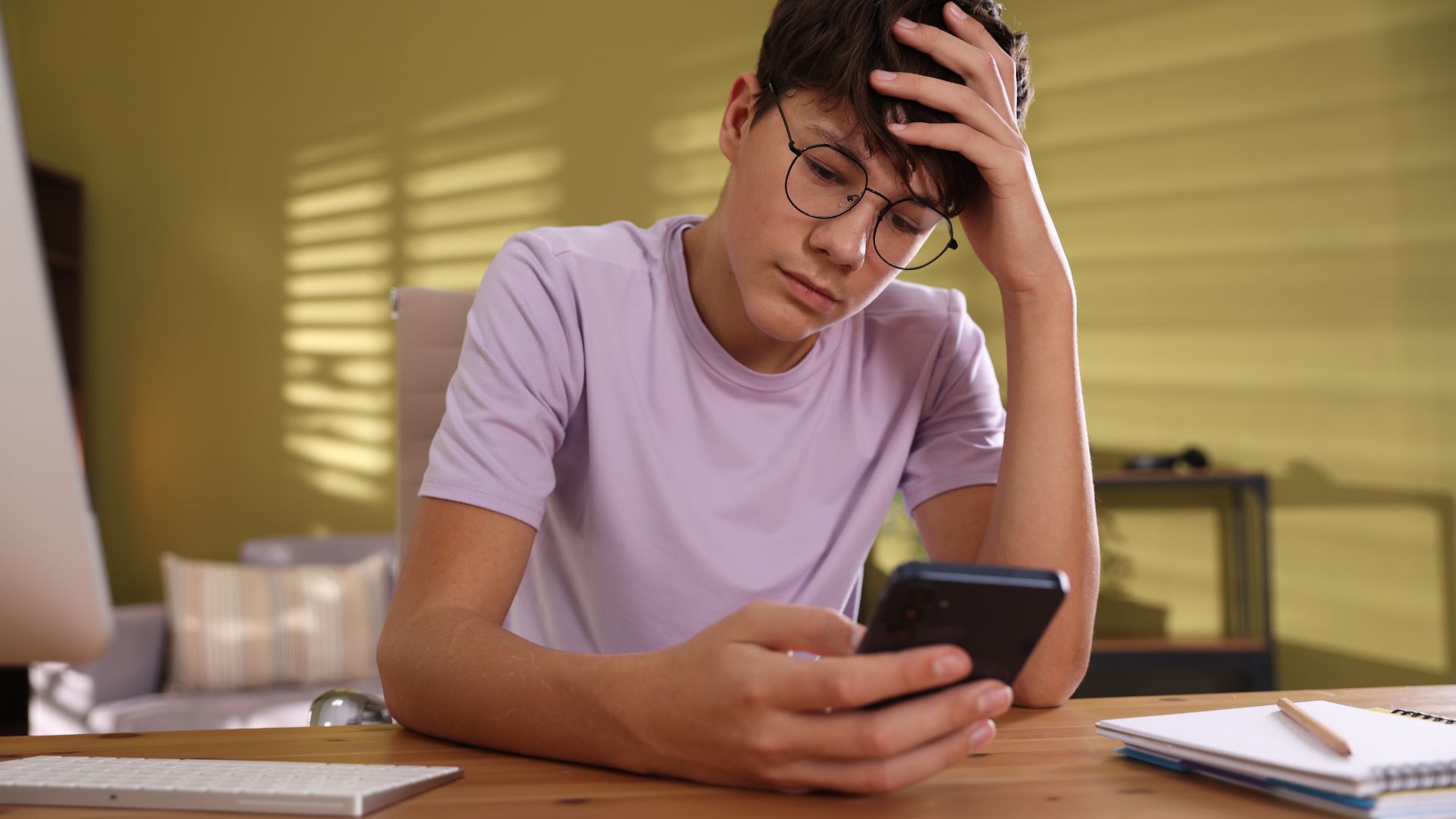 A teenager looking down at their phone.