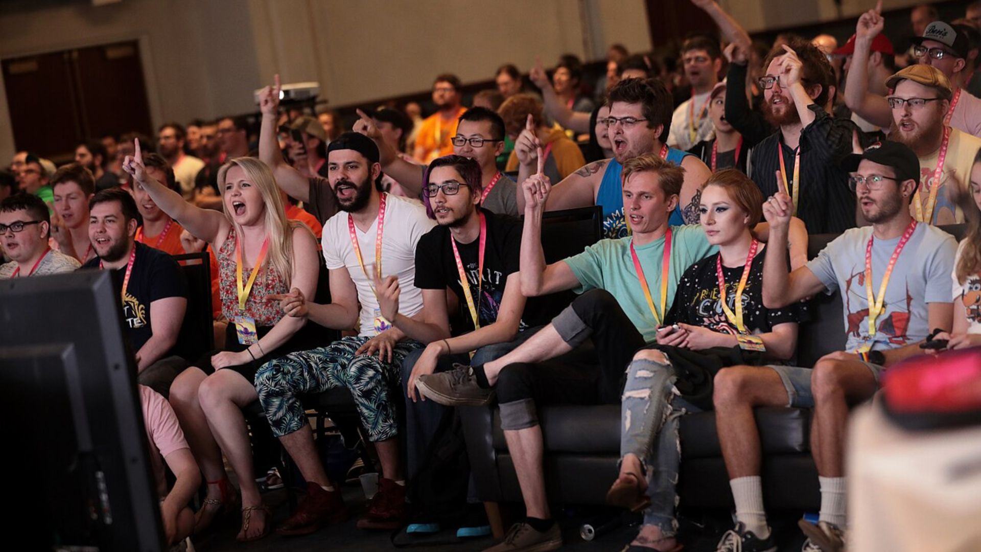 A group of gamers cheering while watching gameplay.