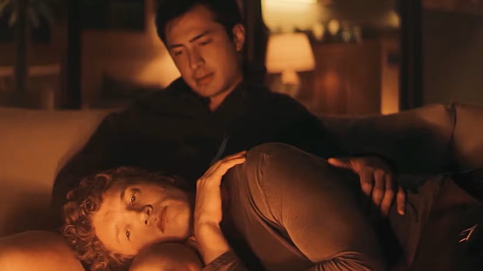 One man comforts another who is lying across his lap.